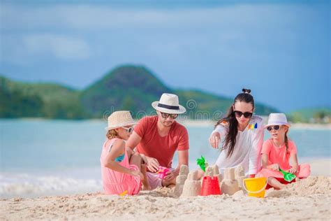 Família Que Faz O Castelo Da Areia Na Praia Branca Em Férias De Verão