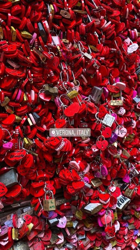 Many Red Padlocks Are Attached To A Wall With A Sign That Says Vernia Italy