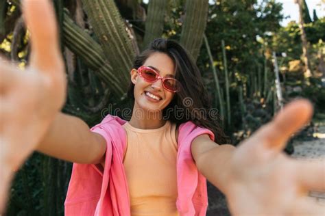 Smiling Young Caucasian Girl Wide Smiling And Stretches Hands At Camera