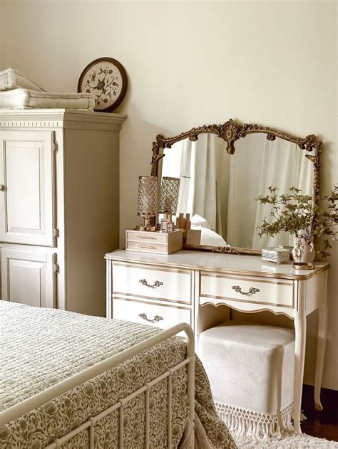 A Bedroom Scene With Focus On The Bed And Dresser Mirror And Clock In