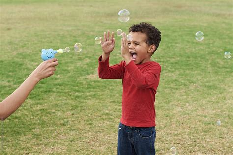 Happy Kid Playing With Soap Bubbles By Stocksy Contributor Per