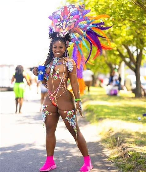 A Woman In A Colorful Costume Is Walking Down The Street