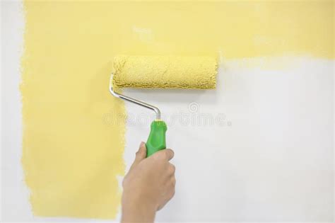 Pared Masculina De La Pintura Del Decorador Con El Rodillo Dentro