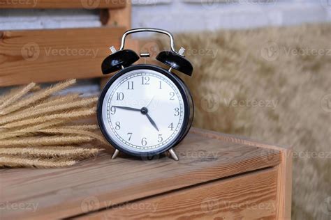 Retro Alarm Clock on wooden desk 16694075 Stock Photo at Vecteezy