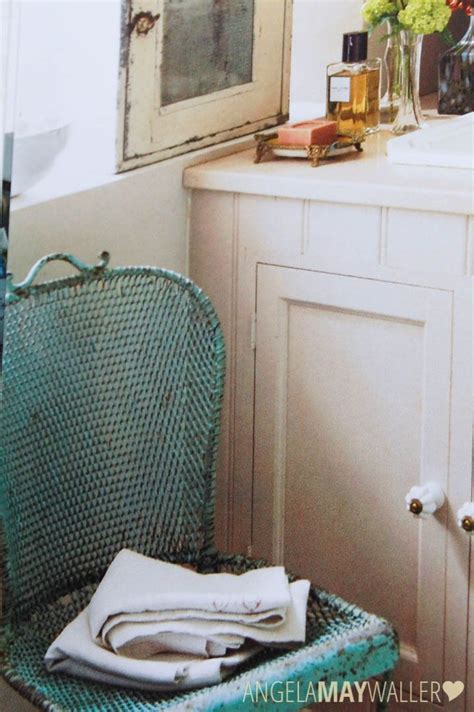 A Green Chair Sitting In Front Of A Window Next To A White Cabinet And Sink