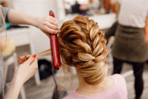 Woman Hairdresser Making Hairstyle To Blonde Girl In Beauty Salon