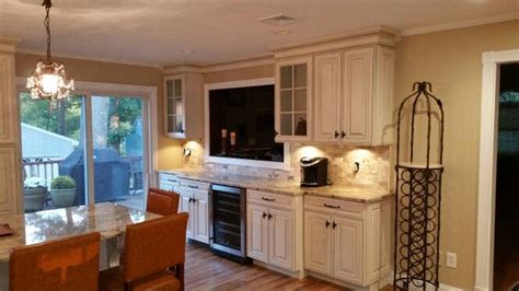 A Kitchen With White Cabinets And Wooden Floors