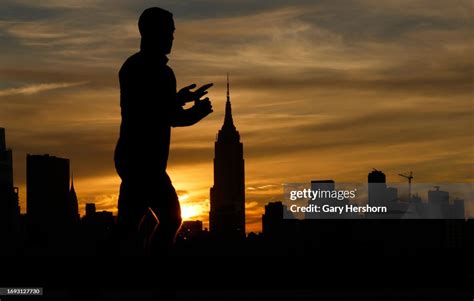 The sun rises behind the Empire State Building in New York City as a ...