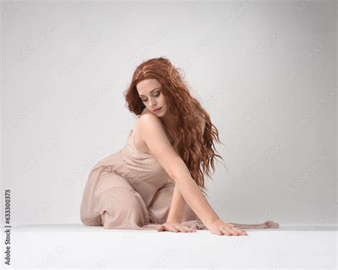 Full Length Portrait Of Beautiful Brunette Model Wearing A Pink Dress Graceful Sitting Pose