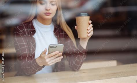 Attentive Blonde Looking At Screen Of Her Gadget Stock Photo Adobe Stock