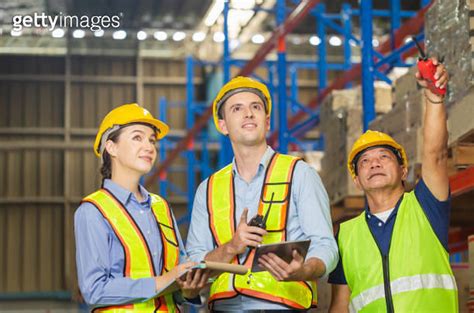 Manager And Supervisor Taking Inventory In Warehouse Foreperson Making