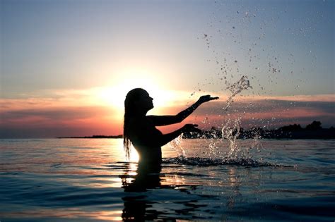 Premium Photo Female Silhouette At Sunset On The Sea Makes A Splash