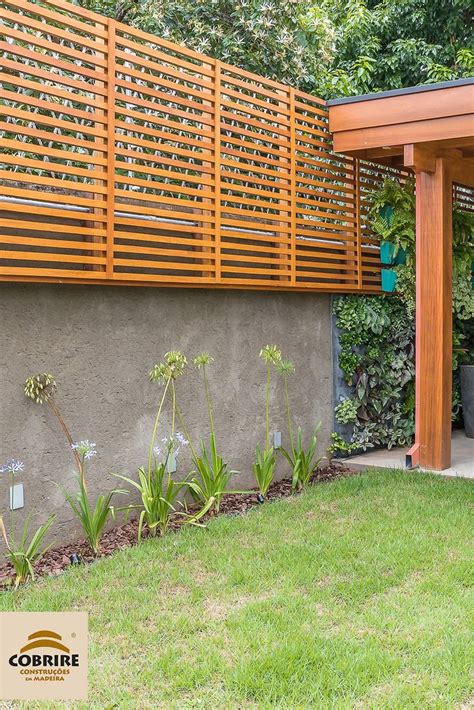 An Outdoor Patio With Wooden Slats And Plants On The Side Of The House