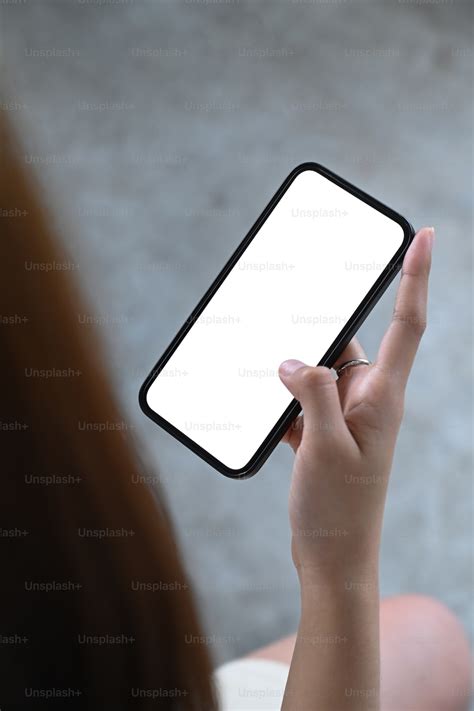 흰색 빈 화면으로 스마트 폰을 들고 있는 젊은 여성을 닫습니다 사진 Unsplash의 사진술 이미지