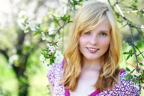 Spring Portrait Of A Beautiful Blonde Girl In Blooming Sunny Garden Close Up Stock Photo