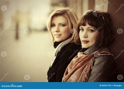 Duas Mulheres Novas Felizes Da Forma Na Rua Da Cidade Foto De Stock