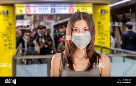 Chinese Woman Wearing Surgical Mask With Defocused Japanese Metro Train Station In Background