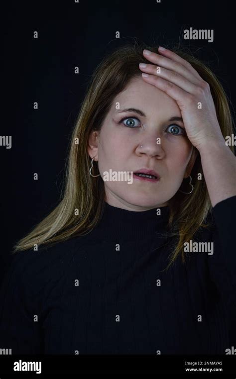 Portrait Of A Beautiful Blonde Woman Who With Her Hand On Her Forehead Seems Distraught At