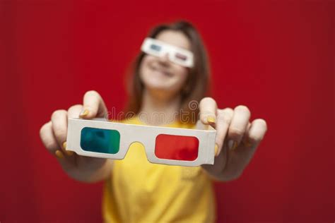 Funny Girl In 3d Glasses On A Red Background Gives Glasses Offers To