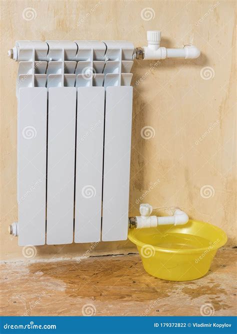 Leaking Radiator and Basin for Collecting Water. Stock Photo - Image of
