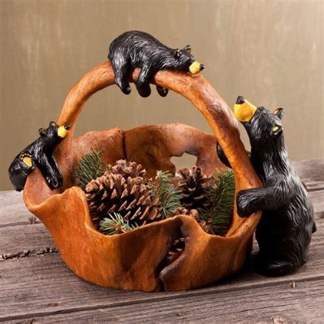 Two Black Cats Sitting On Top Of A Wooden Basket Filled With Pine Cones