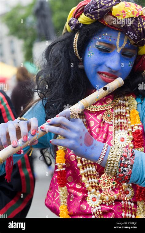 Girl Dressed In A Traditional Costume Of Krishna Playing The Flute