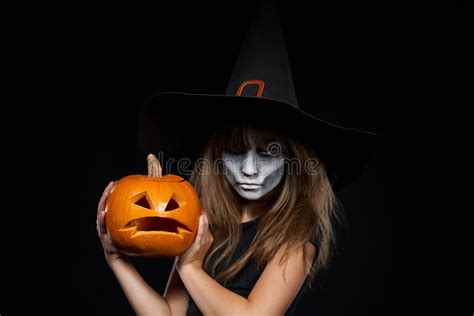 Serious Halloween Witch Holding Jack O`lantern Pumpkin Looking At