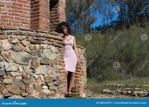 Beautiful Brunette Woman With Curly Hair Among The Ruins Of An Old Abandoned Building The Woman
