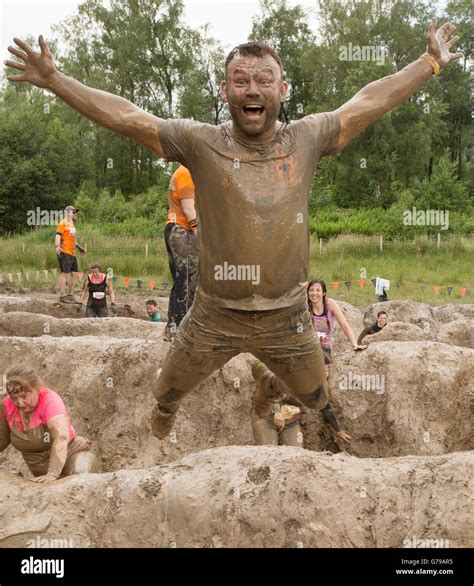 Having Fun At Tough Mudders Mud Mile Obstacle Man Jumping Off Mud