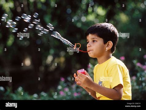 Indian boy child blowing bubbles ; India ; Asia ; MR#560 ; blow bubbles ...