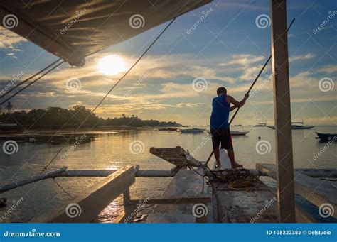 Fisherman On A Banka Traditional Filipino Fishing Boat At Sunset Cebu