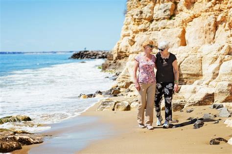 Premium Photo Two Elderly Women Are Walking Along The Rocky Shore