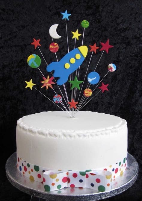 A White Cake With Stars And Rockets On Top