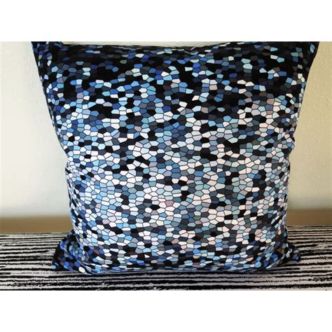 A Black And Blue Pillow Sitting On Top Of A Bed