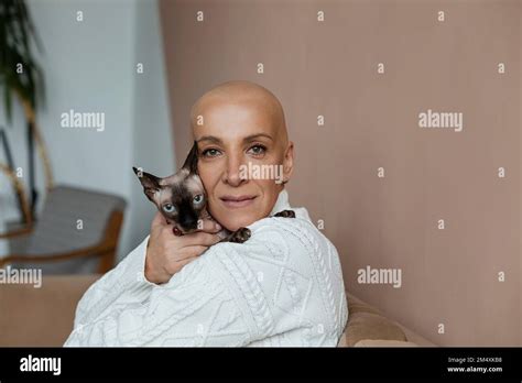 Mature Hairless Woman Embracing Sphynx Cat On Sofa Stock Photo Alamy