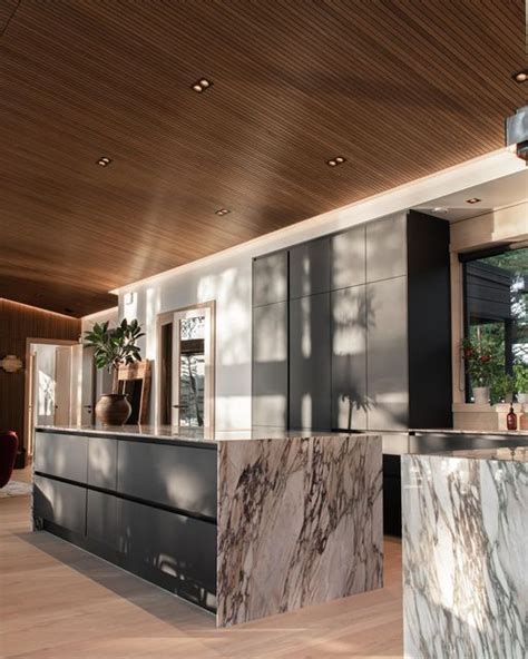 a kitchen with marble counter tops and wooden ceiling