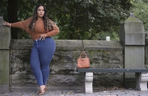 A Woman Leaning Against A Stone Wall Next To A Bench