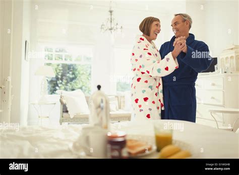 Mature Couple Dancing In Bathrobes In Bedroom Stock Photo Alamy