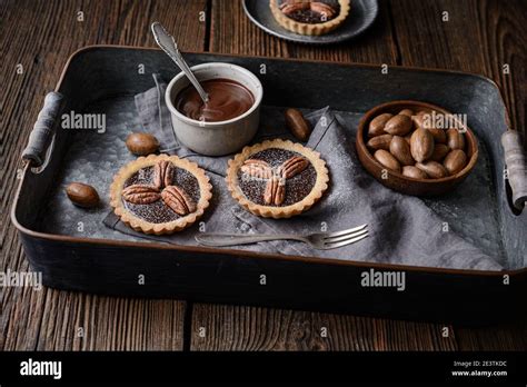 Dark Chocolate Ganache Tarts Topped With Pecans Dusted With Powdered