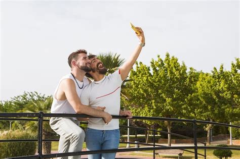 Pareja gay tomándose una foto con su celular Foto Premium