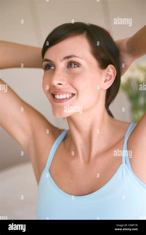 Female Brunette Hair Tied Up Pale Blue Strappy Vest Top Hands Resting On Back Of Head