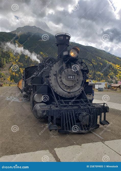 Vertical Shot Of A Locomotive With The Background Of Forest Mountains