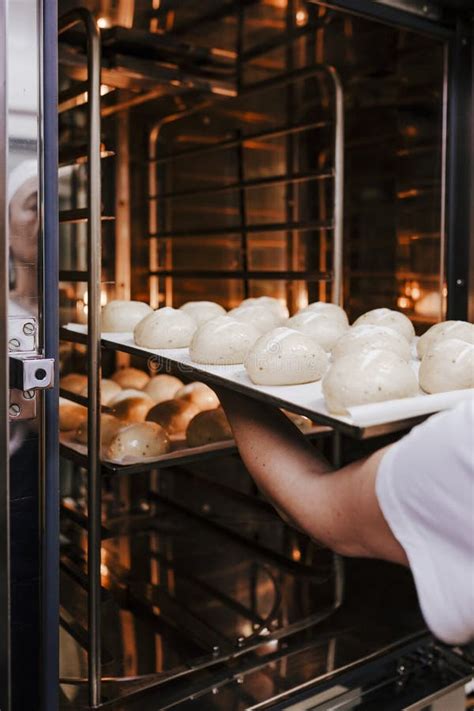 Woman Introducing Bread Baking In Oven Production Oven At The Bakery