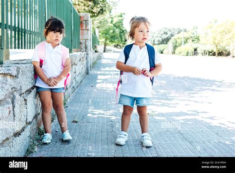 Deux Filles Une Brune Portant Un Sac Dos Rose Et Une Blonde Portant Un Sac Dos Bleu Vont