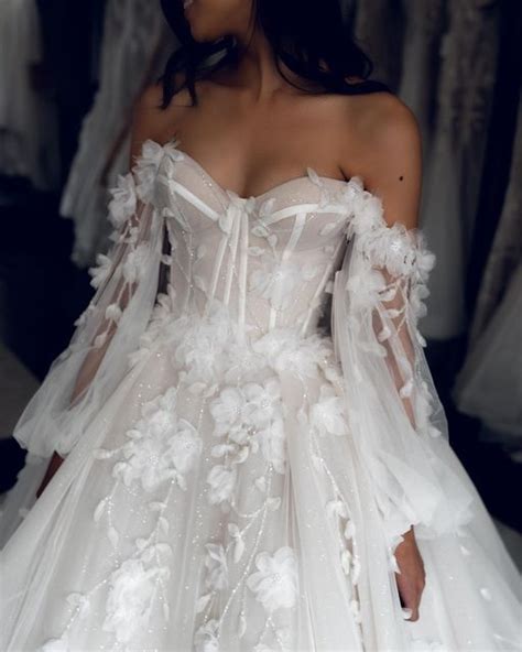 A Woman In A White Wedding Dress With Flowers On It