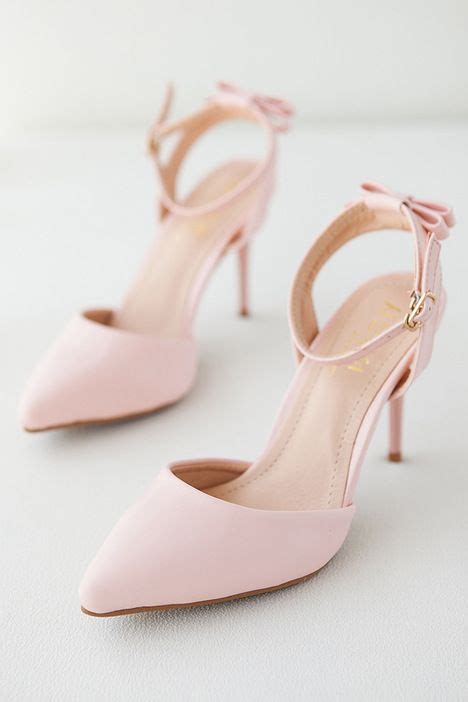 A Pair Of Pink High Heeled Shoes Sitting On Top Of A White Table