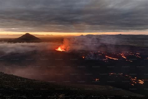 A Volcano Spewing Out Lava At Sunset Photo Iceland Image On Unsplash