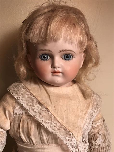 An Old Doll With Blonde Hair And Blue Eyes