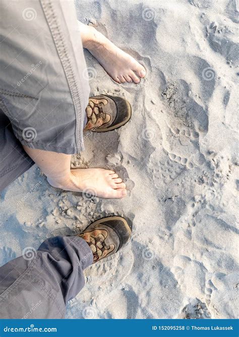 Couple With Naked Feet And Shoes Standing On The Sandy Beach Stock