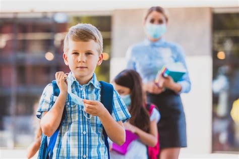 Retrato de un apuesto colegial de elementray quitándose una máscara